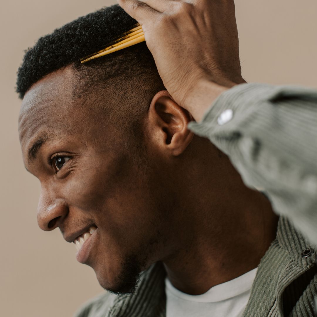 a man combing his hair, smiling