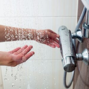A person turning the shower on.